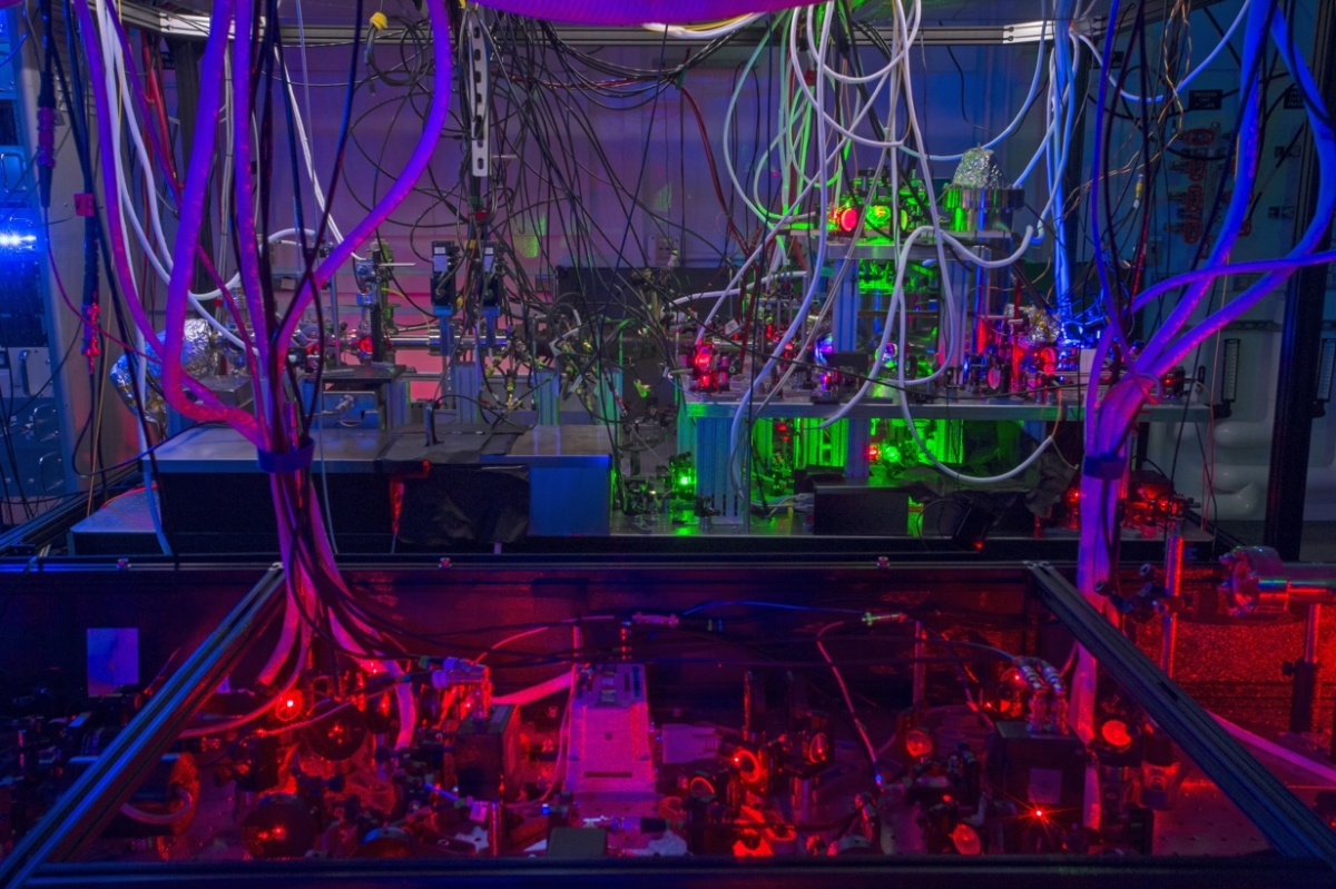 Red, purple and green light shine in the laboratory equipment used to create atomic gases for experiments.
