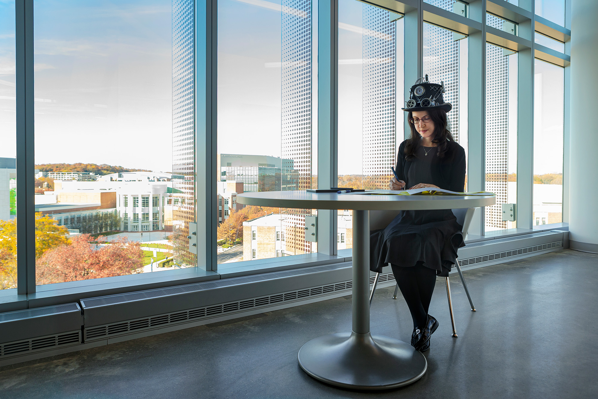 Woman in imaginative hat sitting and reading