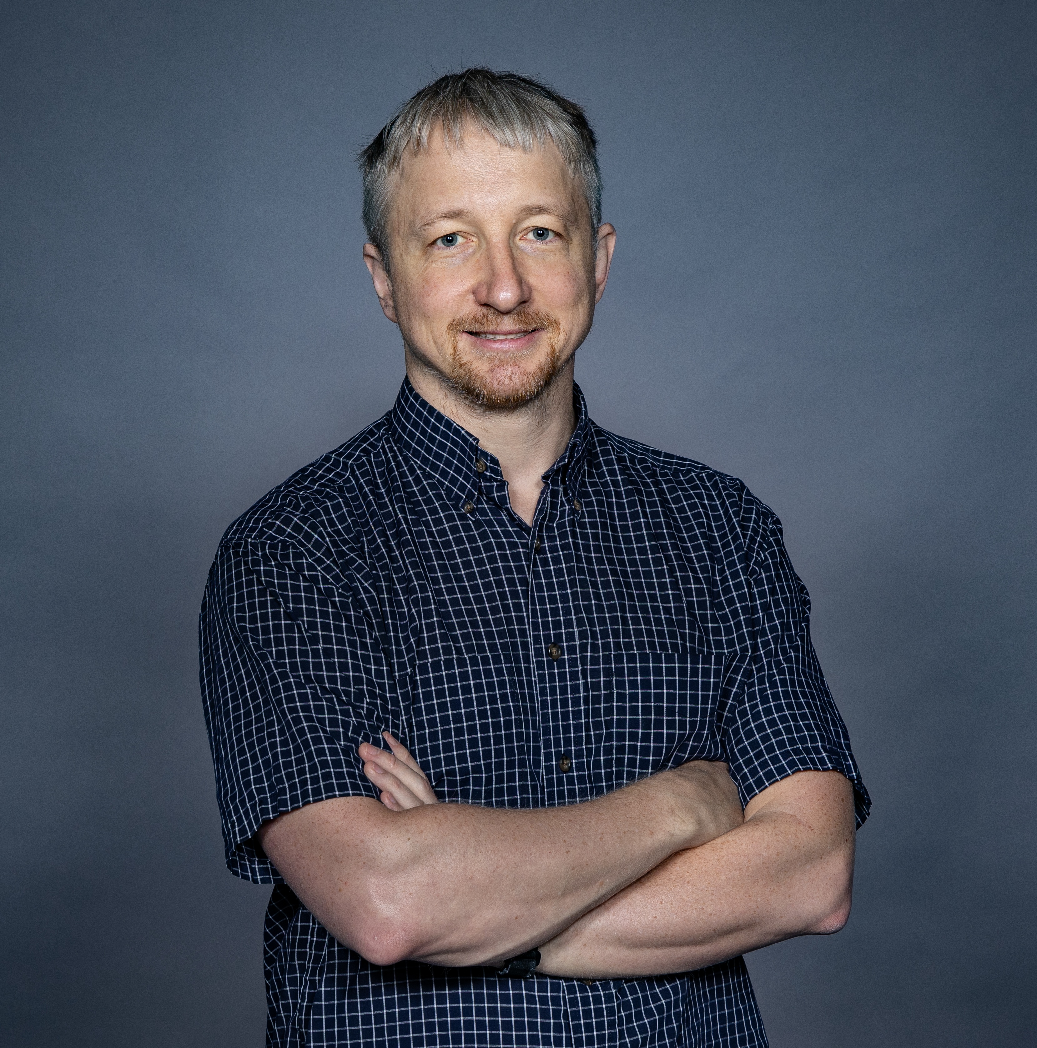 Alexey Gorshkov stands with his arms folded.