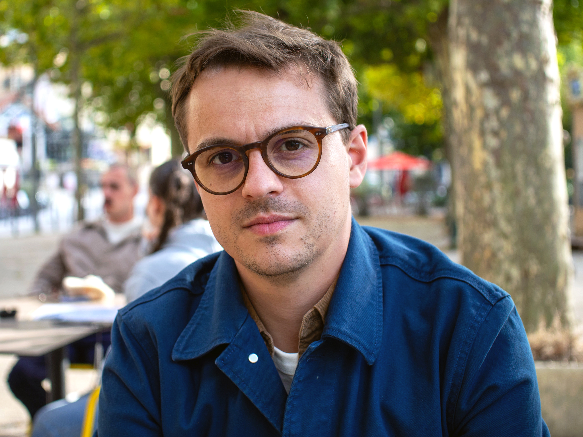 A man in glasses and a blue collared shirt.